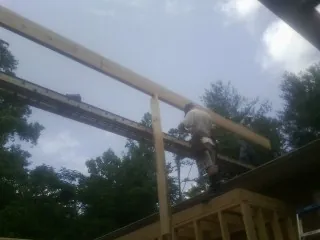 Carpenter setting a ridge beam over a new addition frame — Ice Dam Removal by Roofing Brothers in Sedro Woolley