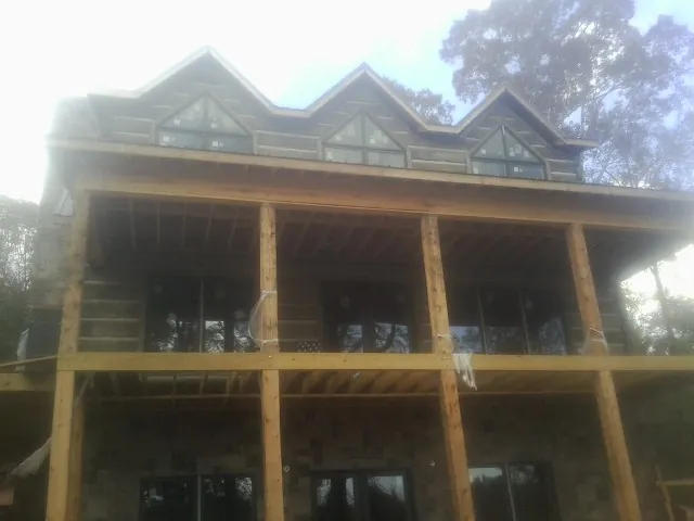 Dormers and porch framing on a large log home under construction — Roof Coating work by our crew in Sedro Woolley