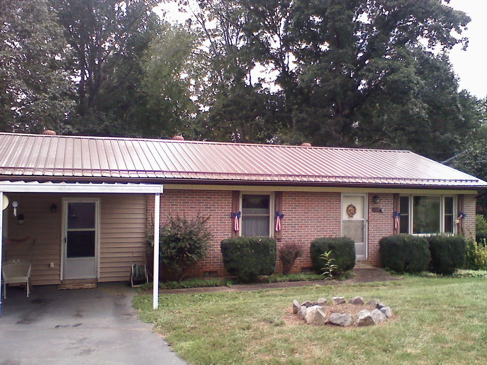 Bronze metal roof and carport on a brick ranch home — Roof Repair work by our crew in Sedro Woolley